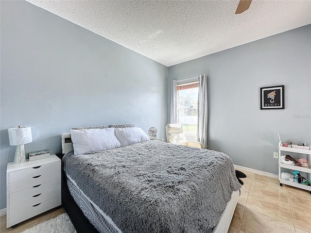 tiled bedroom with ceiling fan and a textured ceiling