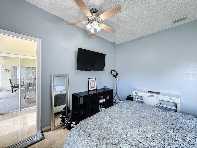 tiled bedroom featuring ceiling fan, a textured ceiling, and lofted ceiling