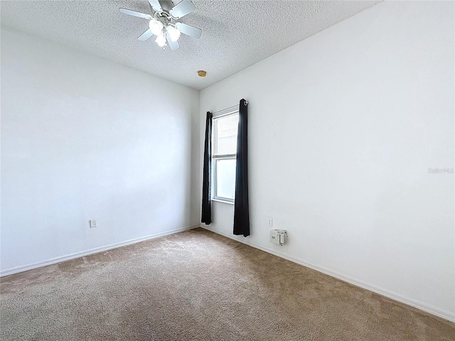 empty room featuring ceiling fan, a textured ceiling, and carpet flooring