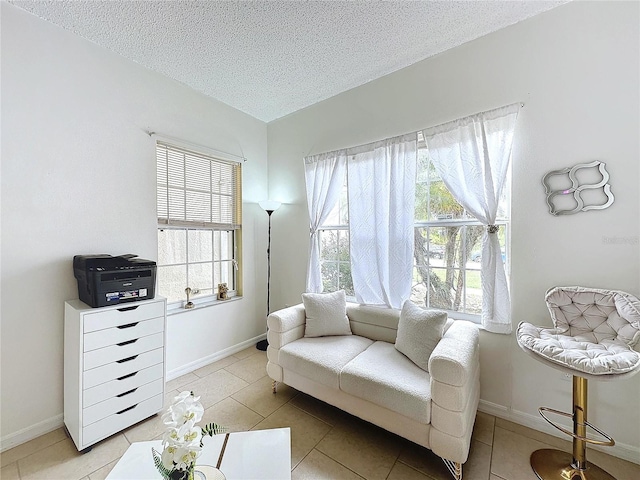 living area with a textured ceiling and light tile patterned floors