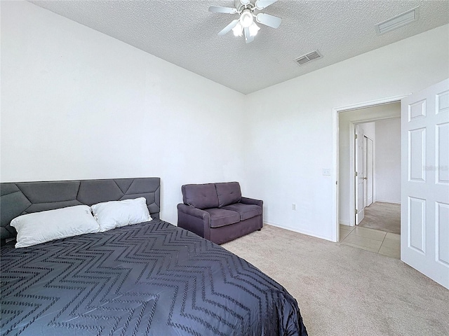 carpeted bedroom with ceiling fan and a textured ceiling