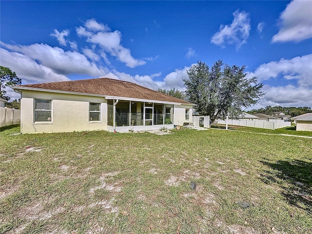 back of property with a yard and a sunroom