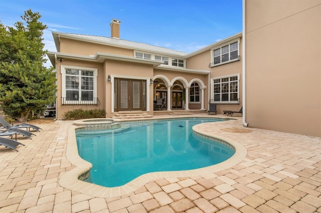 view of pool featuring french doors, an in ground hot tub, and a patio