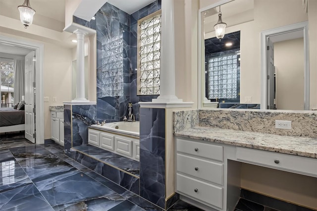 1665 Blue Heron Ln, Lakeland, FL 33813 - full bathroom featuring ornate columns, a garden tub, vanity, ensuite bath, and marble tiled floors