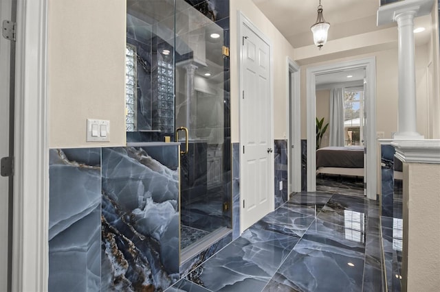 1665 Blue Heron Ln, Lakeland, FL 33813 - ensuite bathroom featuring decorative columns, marble tiled floors, and a stall shower