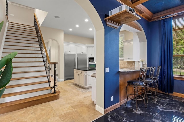 1665 Blue Heron Ln, Lakeland, FL 33813 - bar featuring arched walkways, high end fridge, baseboards, stairway, and recessed lighting
