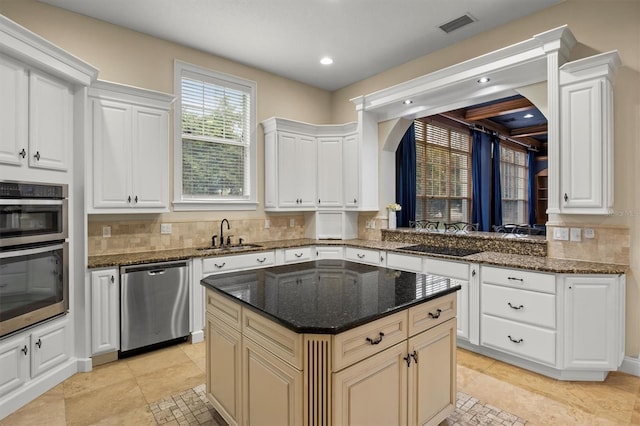 1665 Blue Heron Ln, Lakeland, FL 33813 - kitchen with stainless steel appliances, a sink, a center island, arched walkways, and dark stone counters