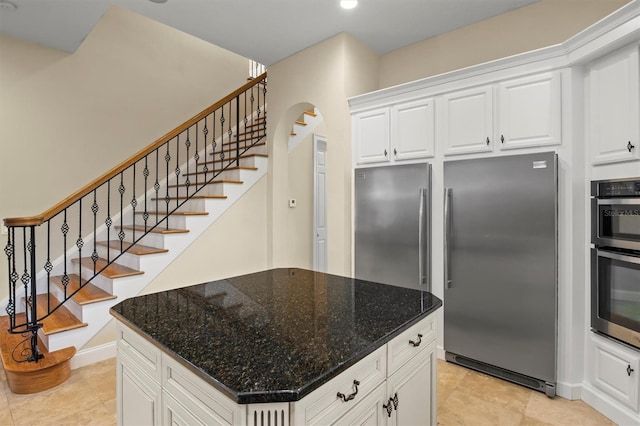 1665 Blue Heron Ln, Lakeland, FL 33813 - kitchen with appliances with stainless steel finishes, arched walkways, dark stone countertops, white cabinets, and recessed lighting