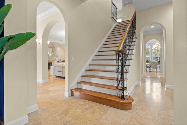 1665 Blue Heron Ln, Lakeland, FL 33813 - stairway with crown molding, arched walkways, and baseboards