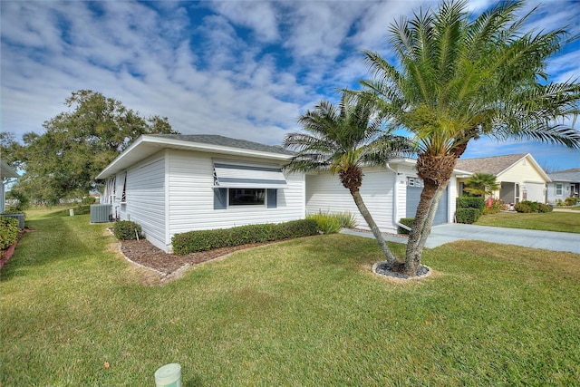 view of front facade with a garage, a front lawn, and central AC