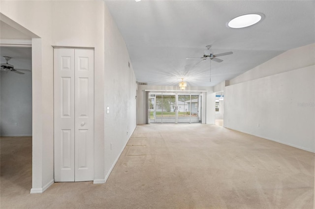 unfurnished living room with ceiling fan, lofted ceiling, and light colored carpet