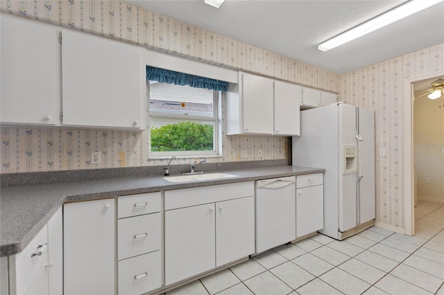 kitchen featuring light tile patterned floors, white cabinetry, sink, and white appliances