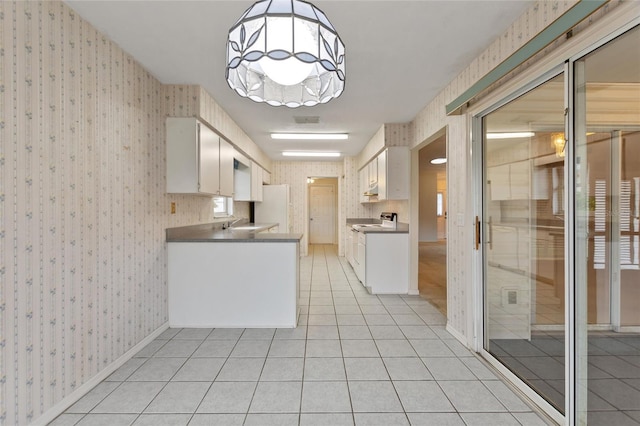 kitchen featuring pendant lighting, sink, light tile patterned floors, white appliances, and white cabinets