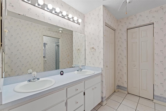 bathroom featuring walk in shower, vanity, tile patterned flooring, and a textured ceiling