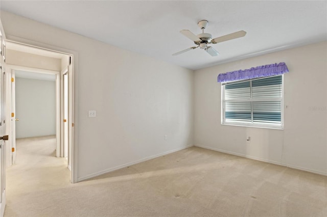 empty room featuring ceiling fan and light colored carpet