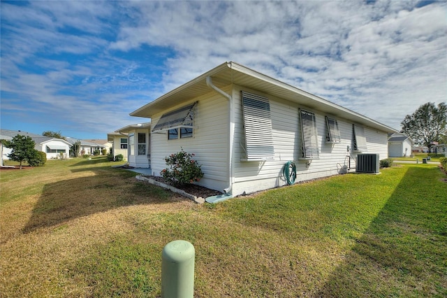 view of property exterior featuring central AC unit and a yard