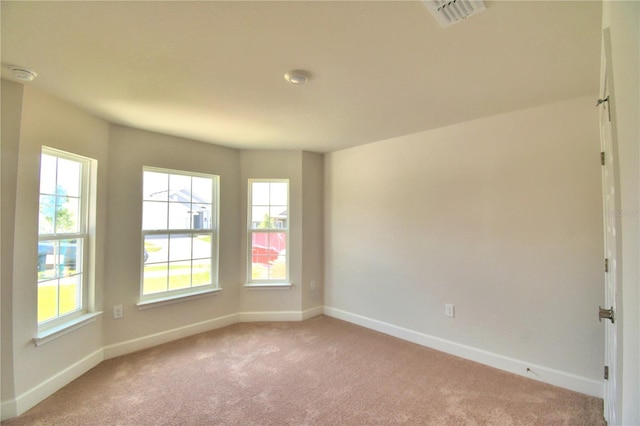 carpeted empty room with a healthy amount of sunlight