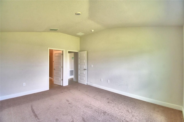 unfurnished bedroom featuring lofted ceiling and carpet floors