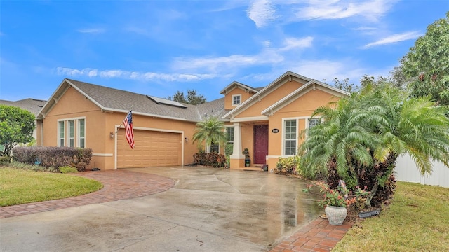 view of front of house with a garage, solar panels, and a front lawn