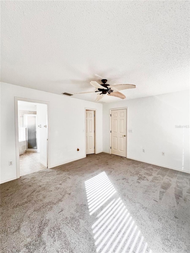 interior space featuring light carpet, a textured ceiling, and ceiling fan