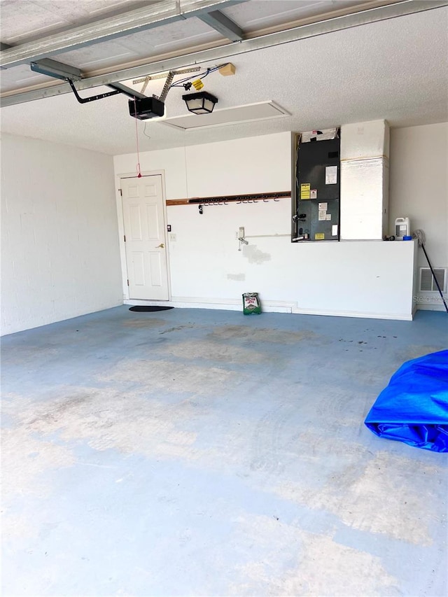 garage featuring a garage door opener and heating unit