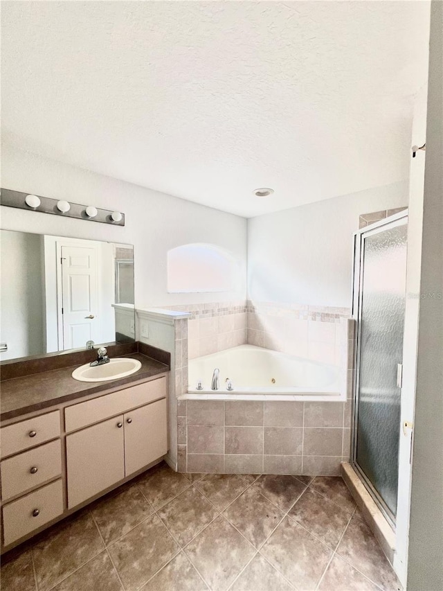 bathroom featuring tile patterned flooring, vanity, separate shower and tub, and a textured ceiling