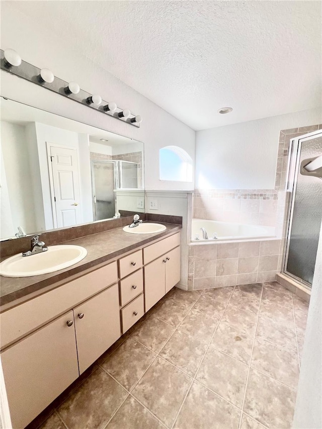 bathroom with vanity, separate shower and tub, tile patterned flooring, and a textured ceiling