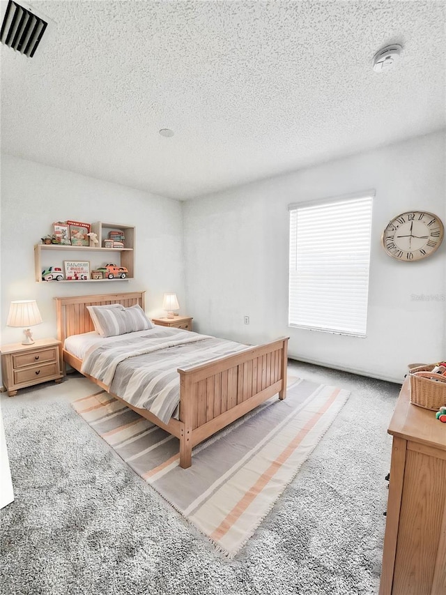 carpeted bedroom featuring a textured ceiling