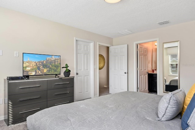 bedroom with connected bathroom, light carpet, and a textured ceiling