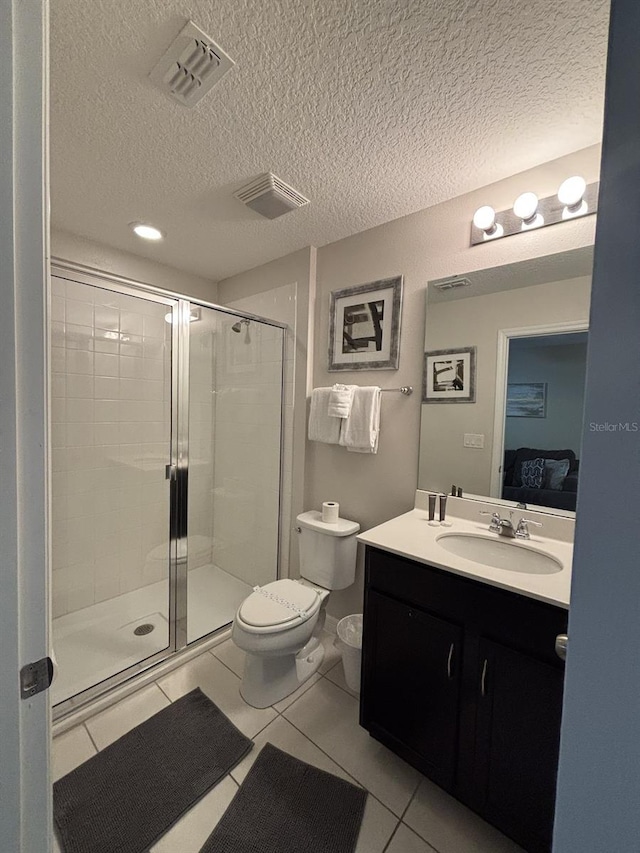 bathroom with a textured ceiling, tile patterned flooring, and a shower with door