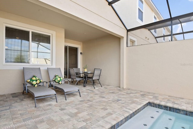 view of patio featuring glass enclosure