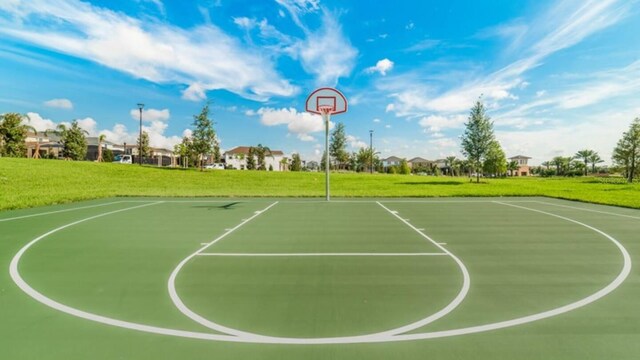 view of sport court featuring a lawn