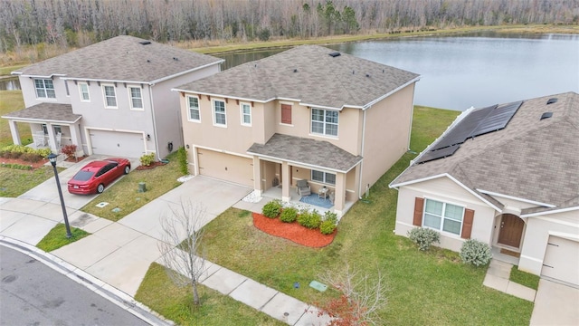 view of front of home featuring a garage, a front yard, a porch, and a water view