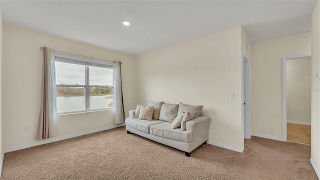 living room with light carpet and a water view