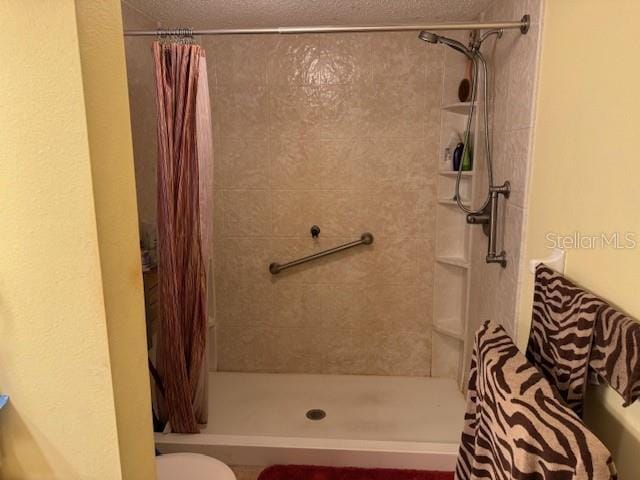 bathroom featuring toilet and a shower with shower curtain