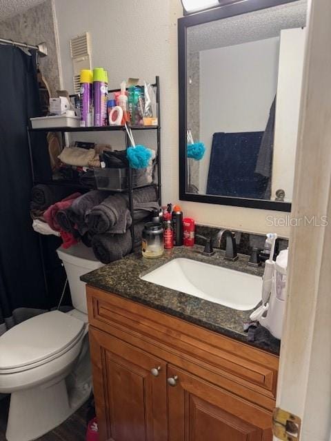 bathroom featuring toilet, walk in shower, and vanity