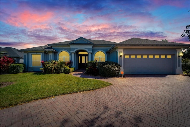 view of front facade with a lawn and a garage