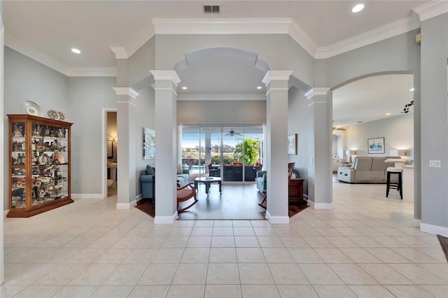 interior space with ornate columns, ceiling fan, a high ceiling, and ornamental molding