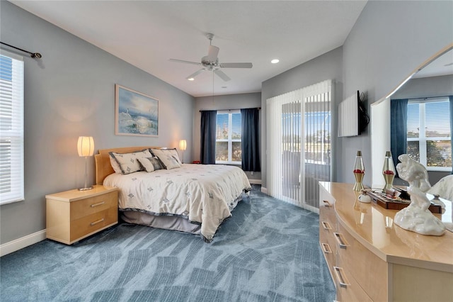 bedroom with ceiling fan, dark carpet, and multiple windows