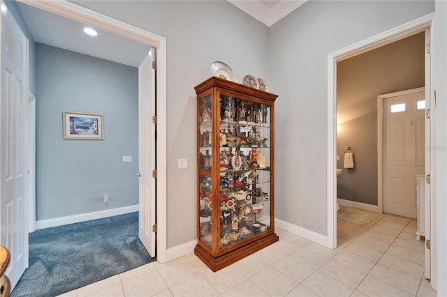 corridor featuring crown molding and light tile patterned floors