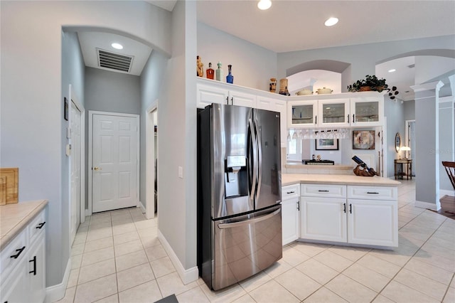 kitchen featuring stainless steel fridge with ice dispenser, kitchen peninsula, white cabinets, and light tile patterned floors