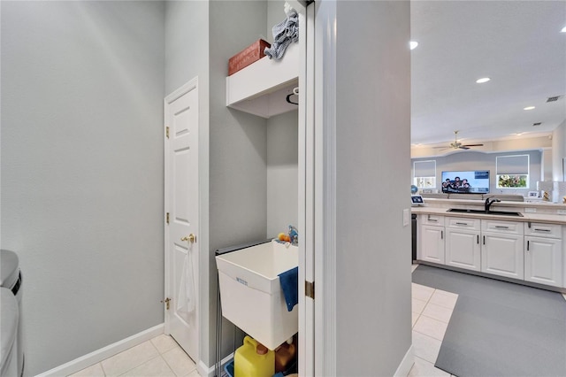 laundry area with ceiling fan, sink, and light tile patterned floors