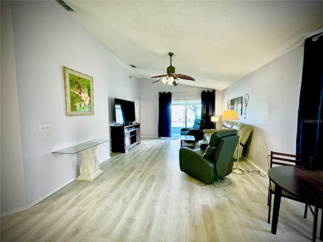 living room featuring a textured ceiling, ceiling fan, lofted ceiling, and light hardwood / wood-style flooring