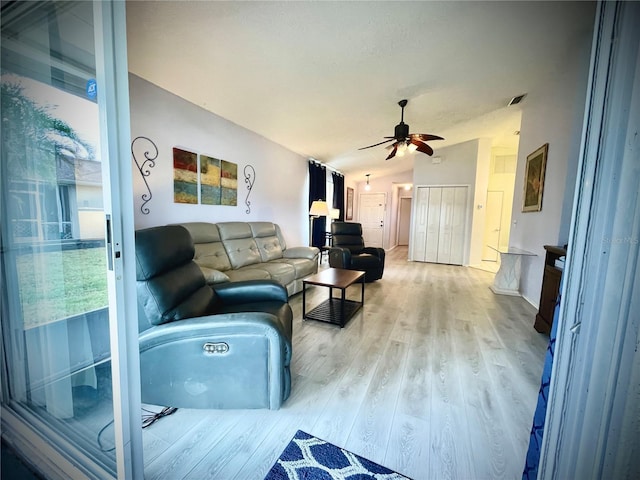 living room featuring ceiling fan, light hardwood / wood-style flooring, and vaulted ceiling