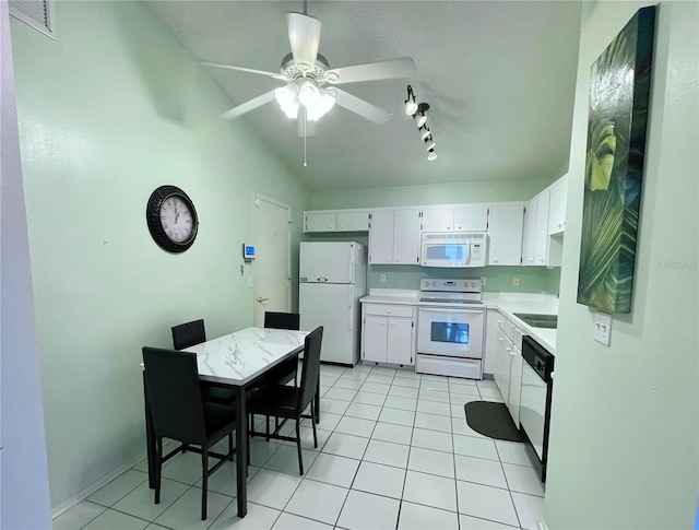 kitchen with light tile patterned floors, white appliances, white cabinets, and vaulted ceiling