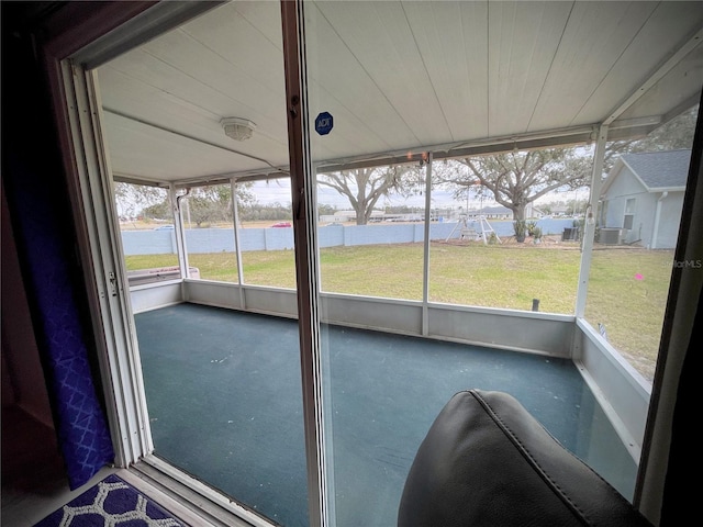 unfurnished sunroom featuring a water view, wood ceiling, and plenty of natural light