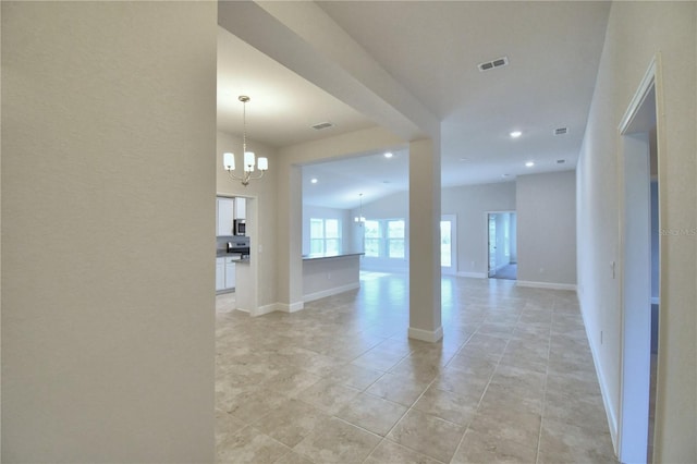 interior space featuring lofted ceiling, light tile patterned floors, and a chandelier