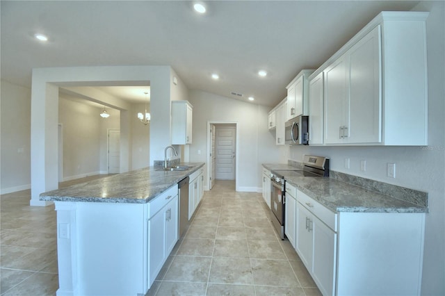 kitchen featuring kitchen peninsula, appliances with stainless steel finishes, dark stone counters, white cabinets, and sink