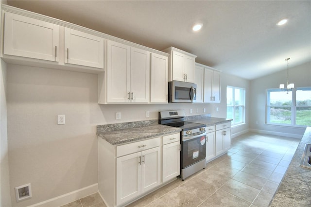 kitchen featuring appliances with stainless steel finishes, a notable chandelier, lofted ceiling, hanging light fixtures, and white cabinets