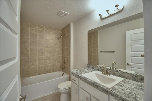 full bathroom featuring toilet, tiled shower / bath combo, tile patterned floors, a textured ceiling, and vanity